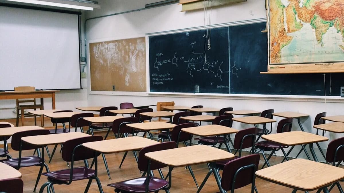 Ein leerer Klassenraum mit Tischen, Tafel und Landkarte. Foto: WOKANDAPIX / Pixabay.