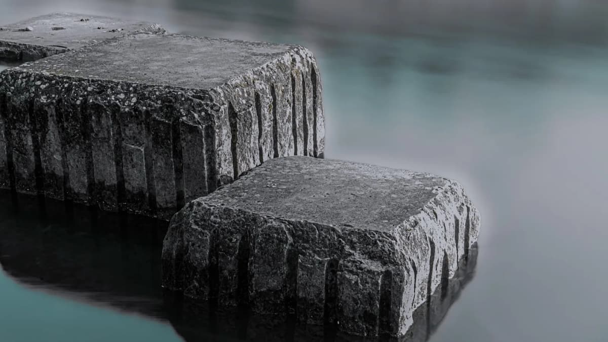 Steinblöcke im stillen Wasser eines Flusses bei Dämmerung. Foto: rieracanler / Pixabay.