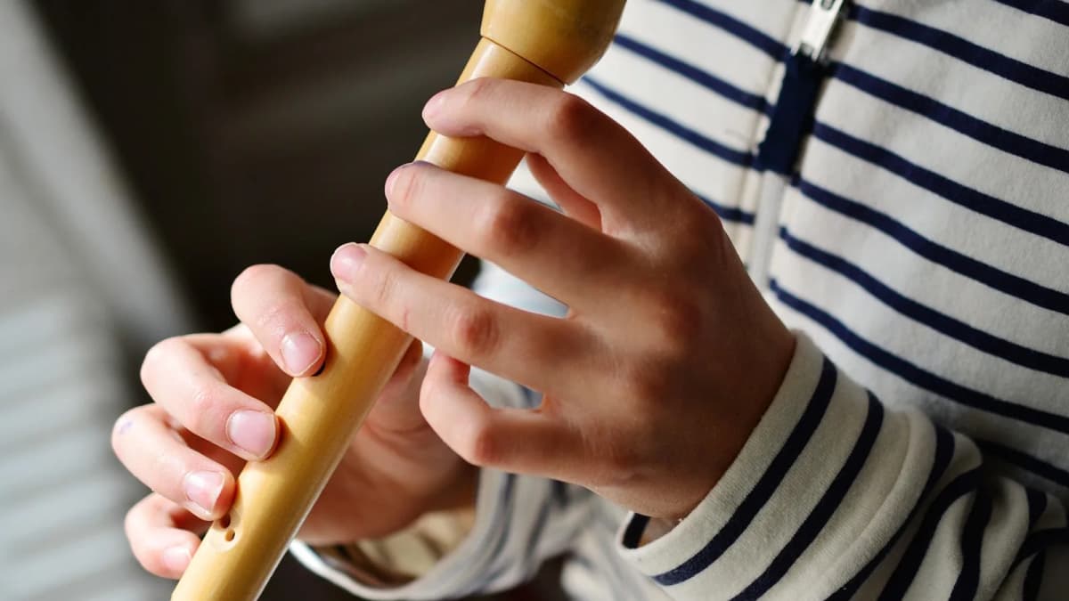 Kinderhände halten und spielen eine helle Blockflöte. Foto: congerdesign / Pixabay.