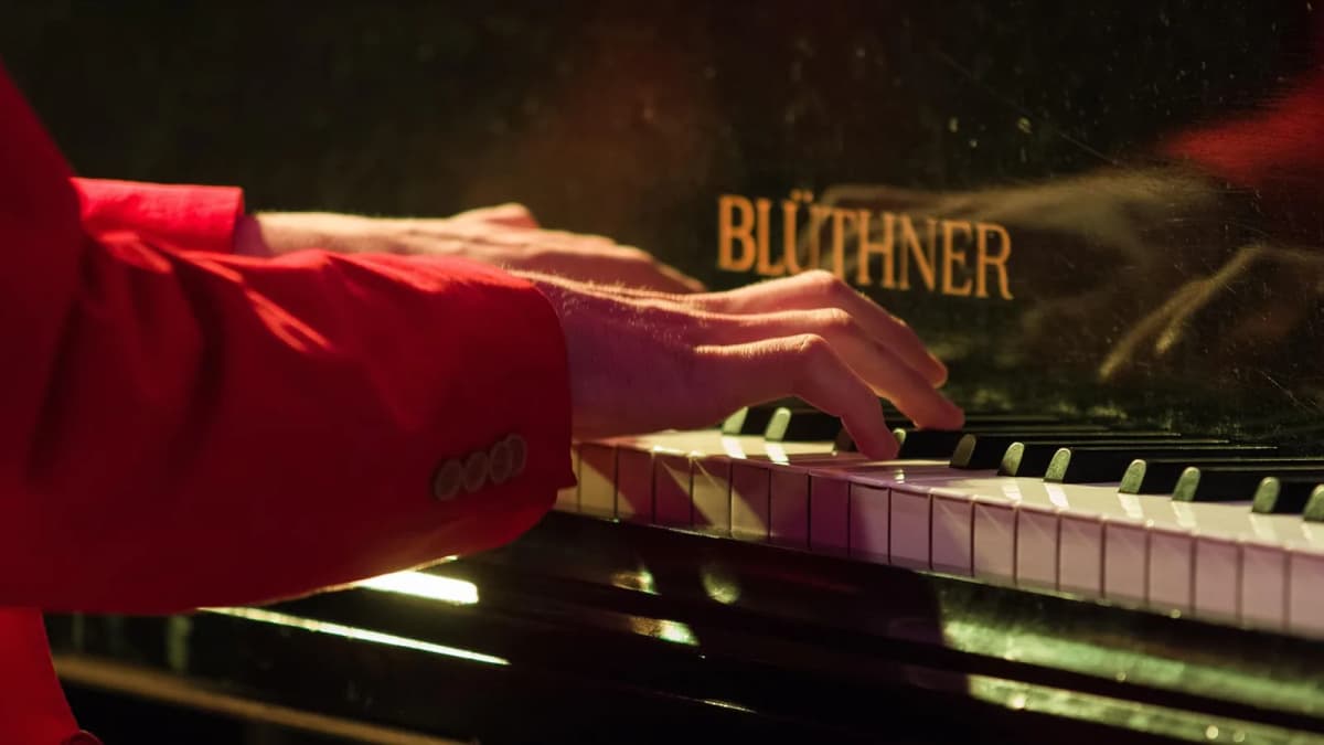 Nahaufnahme einer Hand, die auf den Tasten eines Keyboards spielt. Foto: Sweetaholic / Pixabay.