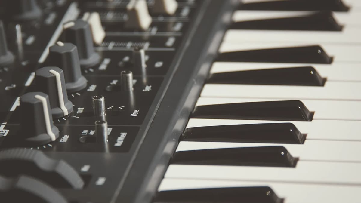 Ein Keyboard mit Reglern und Klaviatur in Schwarz-Weiß-Optik von der Seite. Foto: Pexels / Pixabay.